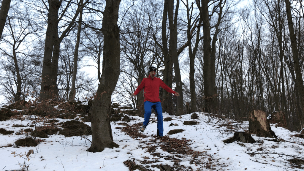 Laufen Im Winter: Chris läuft downhill durch einen winterlichen Wald